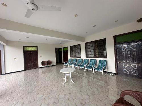 a room with chairs and a table and a door at Hotel comfort hill in Abbottabad