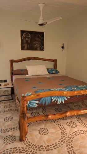 a bedroom with a wooden bed in a room at Amerix resorts and adventures in Diani Beach
