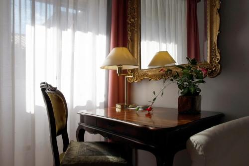 a room with a table with a mirror and a lamp at Albergo Al Viale in Trieste