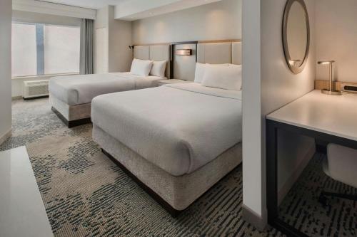 a hotel room with two beds and a mirror at SpringHill Suites Pittsburgh Mills in Tarentum