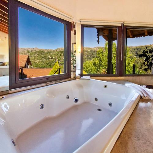 a large white bath tub in a room with windows at Suites de la Colina in La Cumbrecita