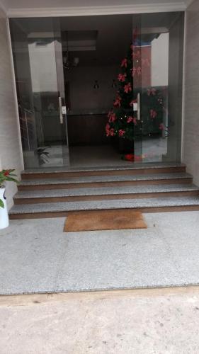 a set of stairs with a welcome mat in front of a building at Hotel Palmeiras Ltda in Duque de Caxias