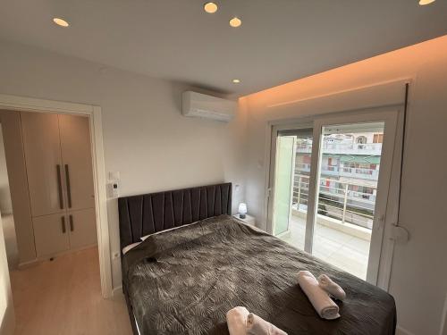a bedroom with a bed with two peoples feet on it at Sea View Luxury Apartment Beachfront 3BR in Agia Triada