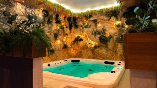 a jacuzzi tub in front of a stone wall at TubHotel in Grottazzolina
