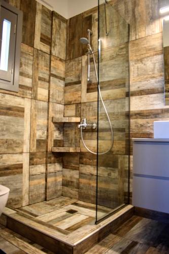 a bathroom with a shower with wooden walls at Delta Villa's Kythnos II in Kithnos