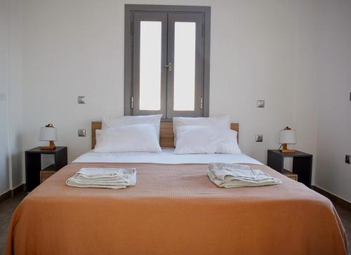 a bedroom with a large bed with two towels on it at Delta Villa's Kythnos II in Kithnos