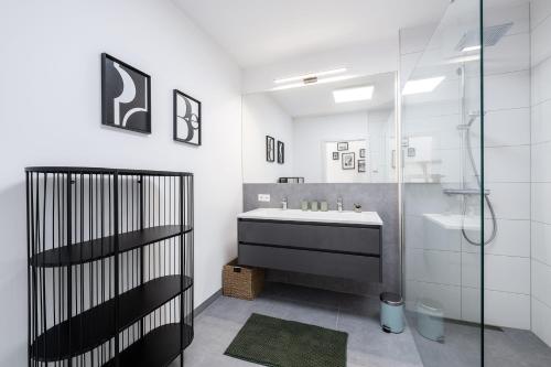 a bathroom with a tub and a sink and a shower at Wiesenblick Residences - by myNests in Haus im Ennstal