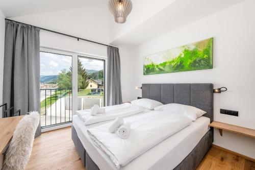 a bedroom with a large bed and a large window at Wiesenblick Residences - by myNests in Haus im Ennstal