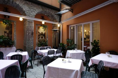 een restaurant met tafels en stoelen met witte tafelkleden bij Albergo Al Viale in Trieste