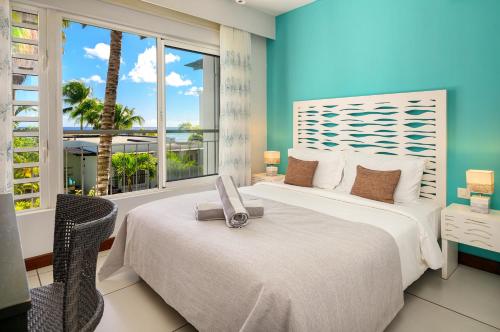two beds in a room with a view of the ocean at Plage Bleue D2 in Trou aux Biches