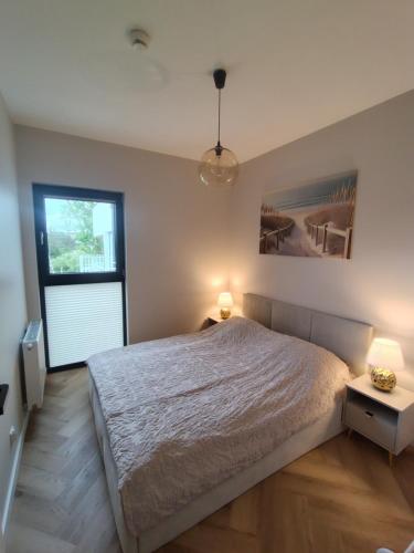 a bedroom with a bed and two lamps and a window at Baltic Porto M66 in Gdańsk
