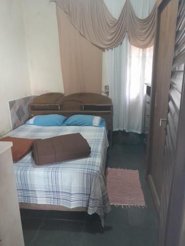 a bedroom with a bed and a window at Casa São Thomé in São Thomé das Letras