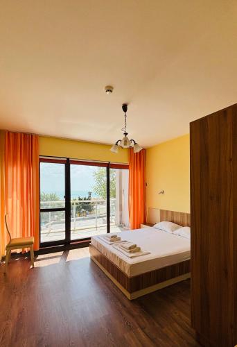 a bedroom with a bed and a large window at IZVORA APART-HOTEL Beach Front Suites in Golden Sands