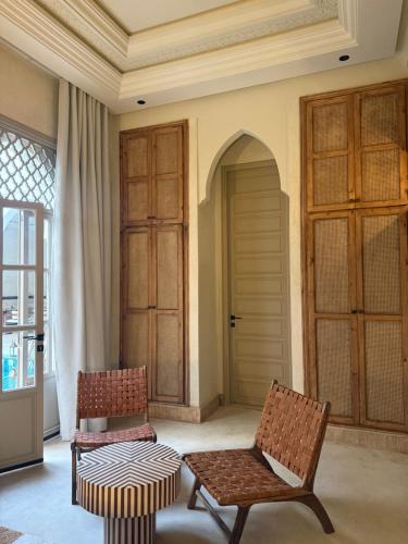 two chairs and a table in a room at Maison Zamane in Marrakesh