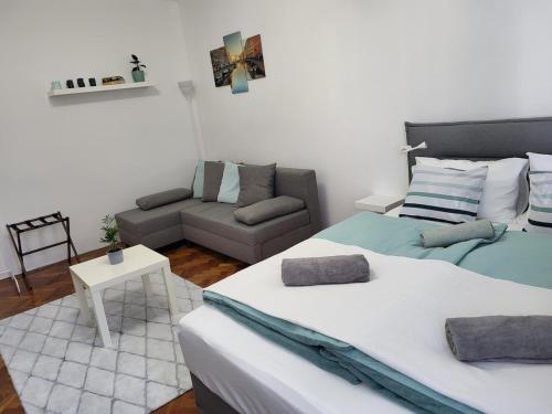 a living room with two beds and a couch at Akvamarin Downtown Apartman in Székesfehérvár