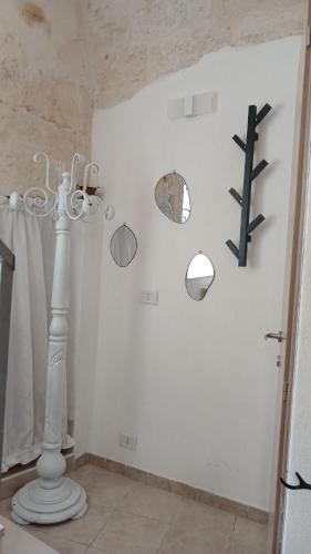 a room with a white wall with a chandelier at Maison della Madia in Triggiano