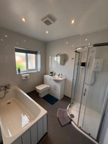 a bathroom with a tub and a toilet and a sink at Kane's Place in Birkenhead