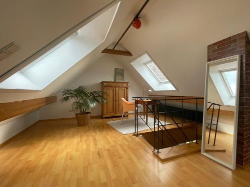 a loft with skylights and a table in a room at Gemütliche Ferienwohnung zwischen Europa-Park und Schwarzwald in Lahr