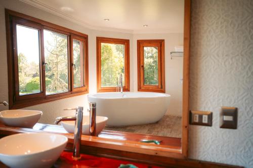a bathroom with a large tub and two sinks at Casa Molino Hotel Boutique & Restaurant Puerto Varas in Puerto Varas