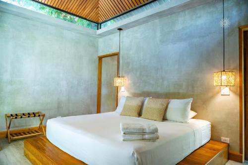 a bedroom with a white bed with two towels on it at Serenity Bungalow in Cocles