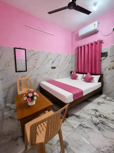 a bedroom with a bed and a table with flowers on it at G3 house Pondicherry in Pondicherry