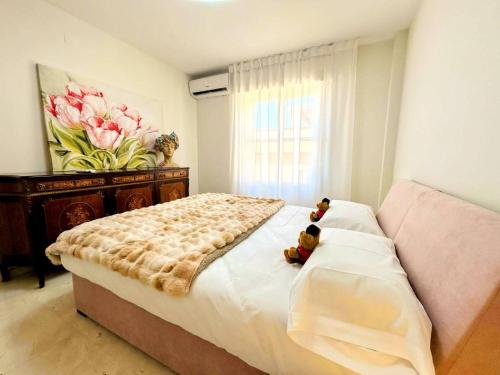 two teddy bears sitting on a bed in a bedroom at Apartment with private parking included - Granada in La Zubia