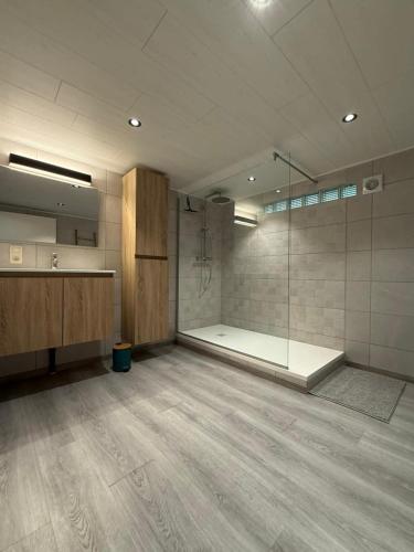 a large bathroom with a shower and a glass shower stall at Le Caroline du Nord in Tenneville
