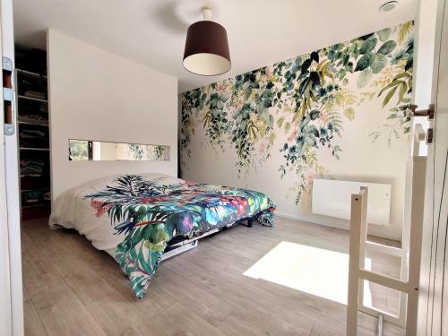 a bedroom with a bed with a floral wallpaper at Le Moulin Hochet in Les Pieux