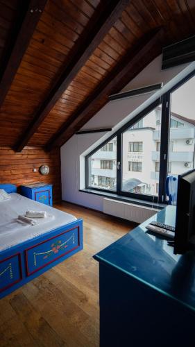 a room with a desk and a large window at Casa Bendis in Eforie Nord
