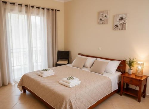 a bedroom with a large bed with two towels on it at Analipsis Messinis Apartments in Análipsis