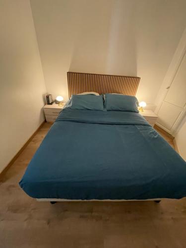 a large bed with blue sheets in a bedroom at Villejuif IGR in Villejuif