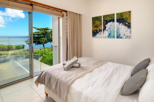 a bedroom with a bed and a view of the ocean at Ocean Point B3 in Pointe aux Piments
