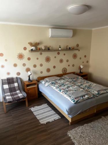 a bedroom with a bed and a chair at Bor-Túra Apartman in Badacsonytördemic