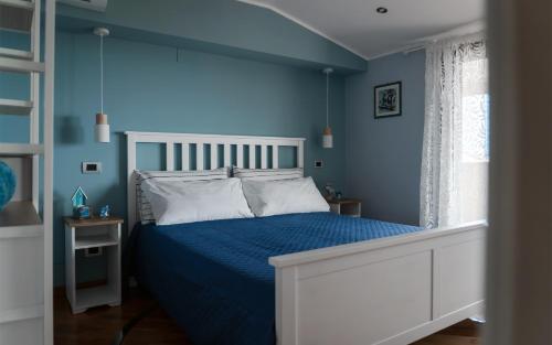 ein blaues Schlafzimmer mit einem Bett und blauen Wänden in der Unterkunft Formia Bellevue in Formia