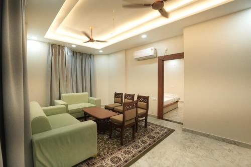 a waiting room with a couch and chairs and a bed at Hotel Chanda in Jhānsi