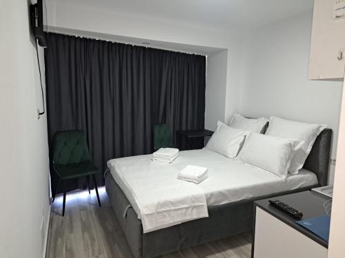 a hotel room with a bed and a green chair at Olimp Sea View Studio in Olimp