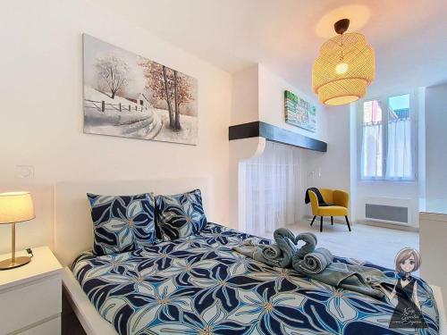 a bedroom with a bed with a blue and white comforter at La petite Maison Rouge in Igon