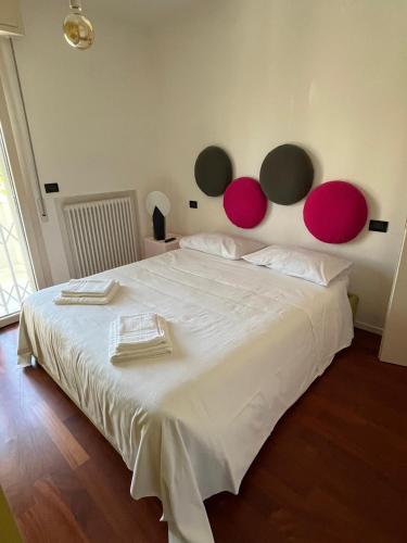 a bedroom with a large white bed with pink circles on the wall at Rifugio a due passi dal mare in Rimini