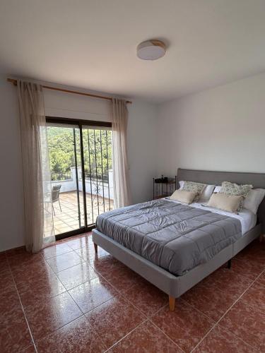 a bedroom with a bed and a large window at Casa Agner in Adsubia