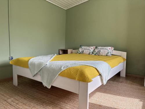 a bed with a yellow blanket and pillows on it at Home for two in Igal