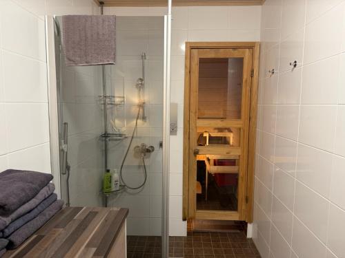 a bathroom with a shower and a glass door at Hamina Bastion Apartments in Hamina