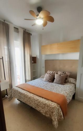 a bedroom with a bed and a ceiling fan at PISO AURORA in Barbate