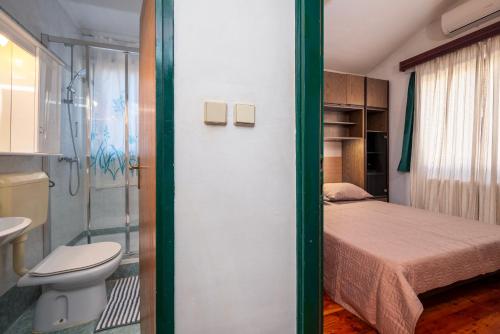 a small bedroom with a bed and a toilet at Moonvidal residence with big private swimming pool and free parking in Pula