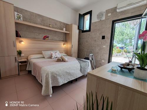 a bedroom with a bed and a desk and a window at Masseria Don Egidio in Melendugno