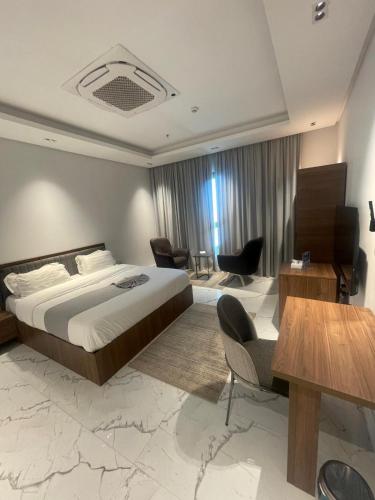 a hotel room with a bed and a table and chairs at Al Safwa One in Al Ḩadd