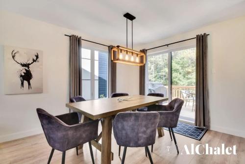 a dining room with a wooden table and chairs at White Stag - Comfort & Serenity - Sauna & Pool in Pont-Rouge