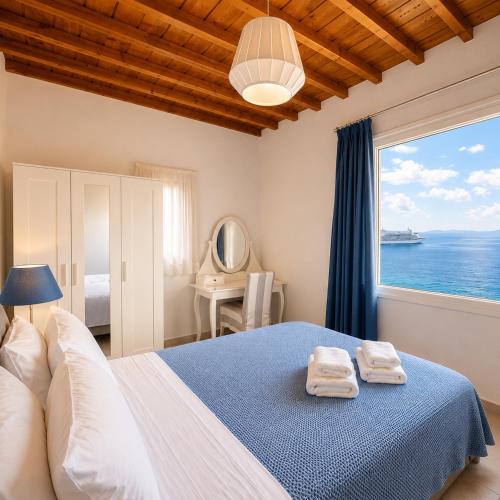 a bedroom with a bed with a view of the ocean at Villa Oceania in Tourlos