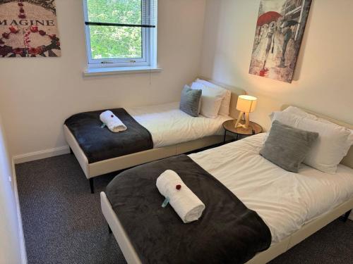 two beds in a room with two beds sidx sidx sidx at Bellshill 2 Bed Apartment in Bellshill