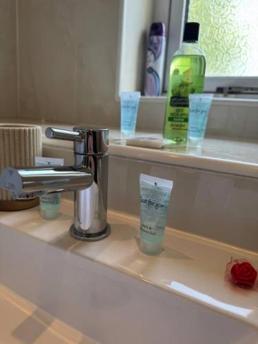 a bathroom sink with a toothbrush and a cup on it at Bellshill 2 Bed Apartment in Bellshill