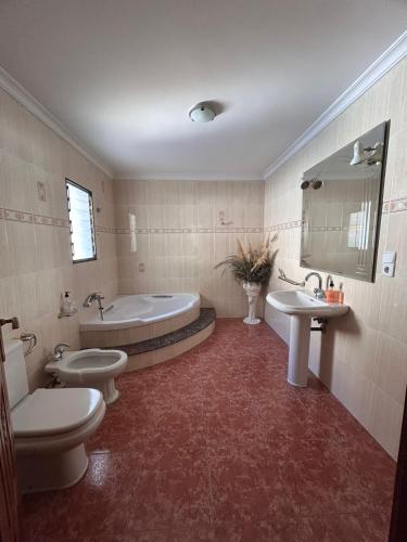 a bathroom with two toilets and a tub and a sink at Casa Agner in Adsubia
